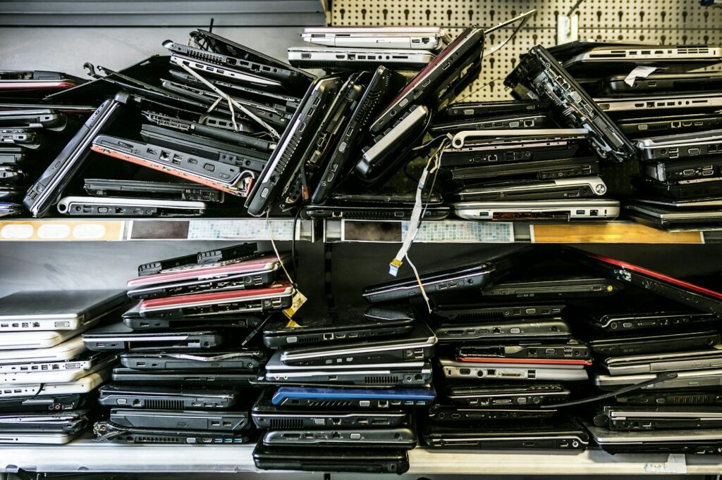 Pile of old, discarded laptops on shelf